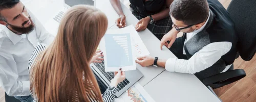jeunes-employes-assis-au-bureau-a-la-table-et-a-l-aide-d-un-ordinateur-portable-un-concept-de-reunion-de-remue-meninges-de-travail-d-equipe-scaled